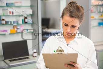 Junior pharmacist writing on clipboard