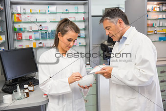 Junior pharmacist mixing a medicine with her senior