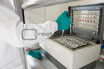 Young scientist using a pipette in chamber
