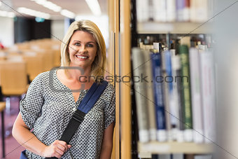Mature student studying in the library with tablet