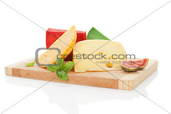Colorful cheese assortment on chopping board.
