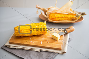 Closeup on boiled corn and butter on cutting board