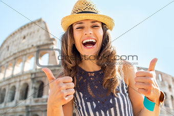Portrait of happy young woman showing thumbs up in front of colo