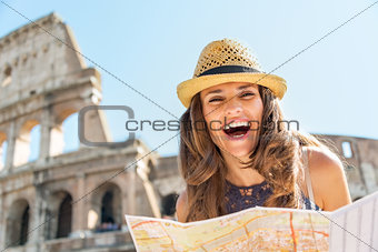 Portrait of happy young woman with map in front of colosseum in 