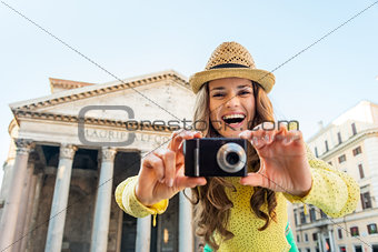 Smiling young woman taking photo in front of pantheon in rome, i