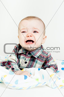 Adorable baby screaming in a plaid shirt