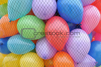 multicoloured toy balloons in a net