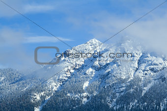 mountain rocks in snow over blue sky