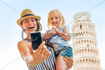 Portrait of happy mother and baby girl making selfie in front of