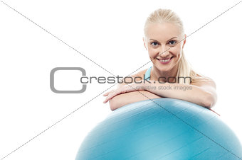 Woman in gym relaxing beside exercise ball