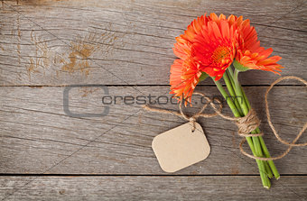 Orange gerbera flowers with tag