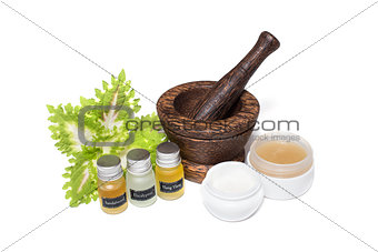 Wooden pounder with bottles of organic oils and cream isolated