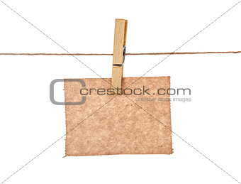 sheet of kraft paper hanging on a rope with clothespin on a whit