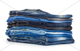 stack of different shades of blue jeans on a white background