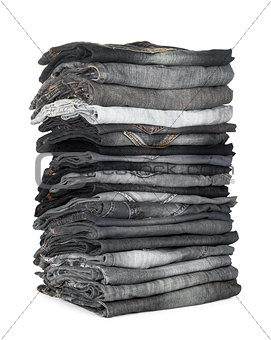 high stack of jeans gray and black on a white background