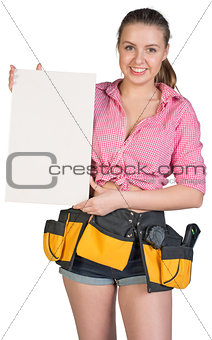 Woman in tool belt holding ceramic tile