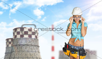 Woman in hard hat adjusting protective glasses