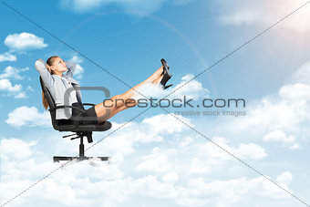 Businesswoman dreaming in clouds