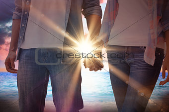 Composite image of hip young couple holding hands
