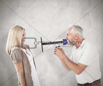 Composite image of angry man shouting at girlfriend through megaphone