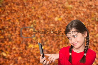 Composite image of cute little girl using smartphone