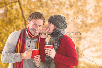 Composite image of couple both having warm drinks