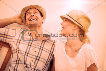 Young hip couple laughing on bench