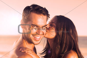 Attractive woman kissing her boyfriend on the cheek