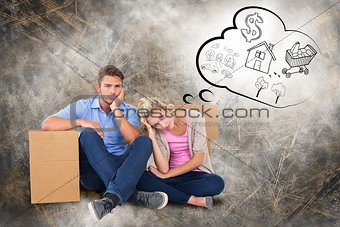 Composite image of unhappy young couple sitting beside moving boxes