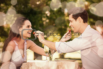 Couple feeding strawberries to each other at outdoor café