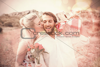 Cute couple going for a picnic with woman kissing boyfriends cheek