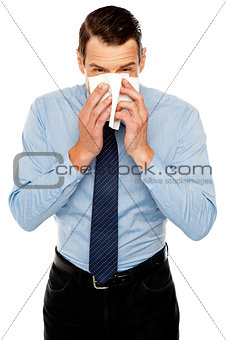 Young man having severe cold. Sneezing