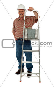 Smiling construction worker holding ladder