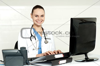 Smiling female doctor working on computer