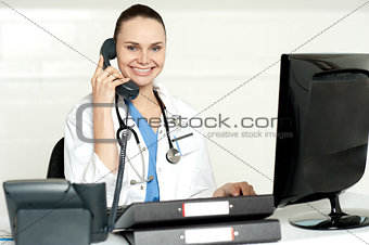 Young smiling physician sitting in clinic