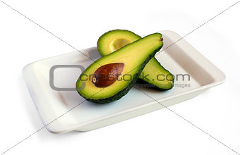 fresh avocado cut in half on square plate