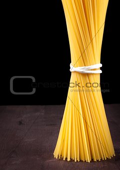 raw pasta spaghetti on wood table with space for text