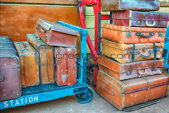 Old suitcases on trolleys in a station