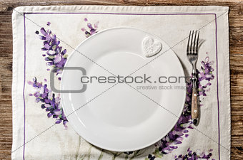 Plate and fork laid on vintage wooden dining table 