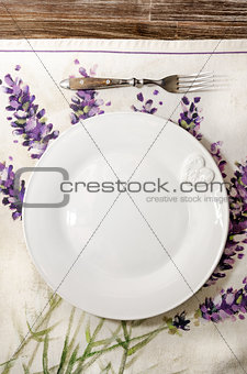 Fork and plate laid on vintage wooden dining table 