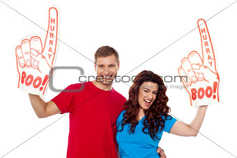 Young couple showing boo hurray foam hand