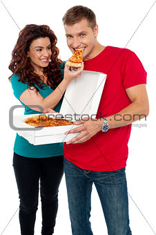 Caring girlfriend making her boyfriend eat pizza
