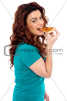 Side pose casual pretty girl enjoying pizza