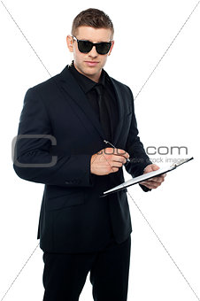 Security officer writing on clipboard