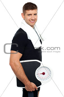 Healthy young man with a weight scale