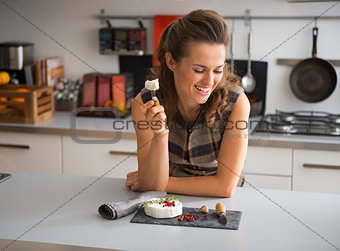 Happy young woman eating camembert