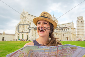 Smiling young woman with map on piazza dei miracoli, pisa, tusca