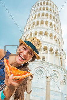 Happy young woman with pizza in front of leaning tower of pisa, 