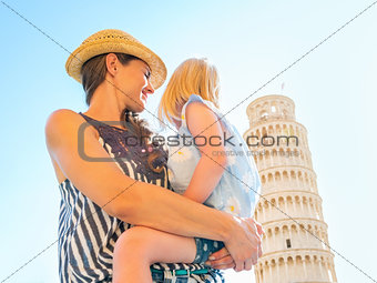Mother and baby girl looking on leaning tower of pisa, tuscany, 