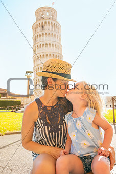 Mother and baby girl kissing in front of leaning tower of pisa, 